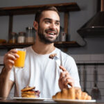 Image,Of,Young,Guy,30s,Sitting,At,Table,And,Eating